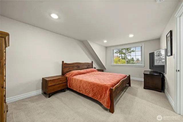 a bedroom with a bed and a flat tv screen on the dresser