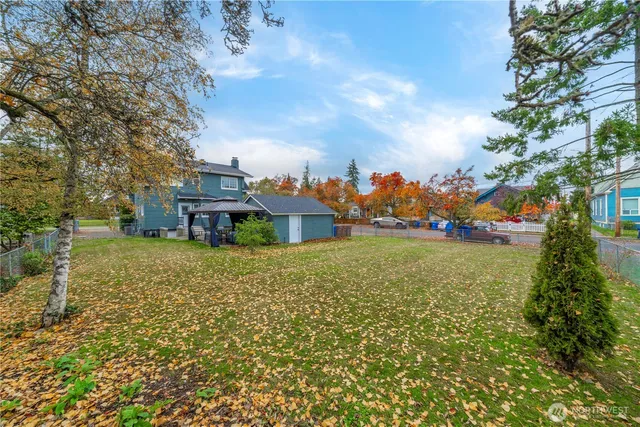 a view of a house with a big yard and large trees