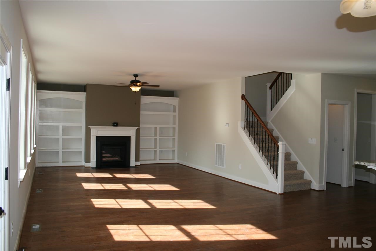 8605 Hurst Drive Raleigh, NC 27603 - Photo 4 of 17 a view of an empty room with wooden floor fireplace and a window