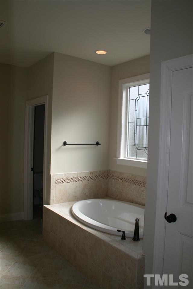 8605 Hurst Drive Raleigh, NC 27603 - Photo 10 of 17 a bathroom with a bathtub and a shower