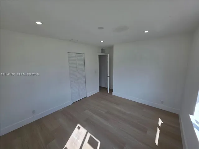 a view of empty room with wooden floor