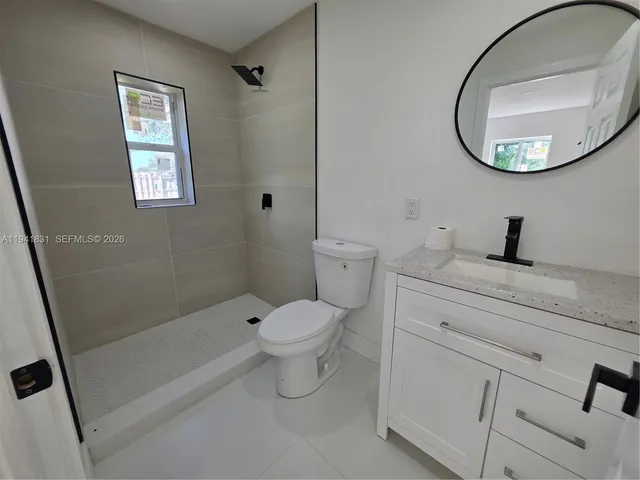 a bathroom with a toilet sink vanity and mirror