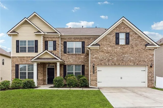 a front view of a house with a yard and garage