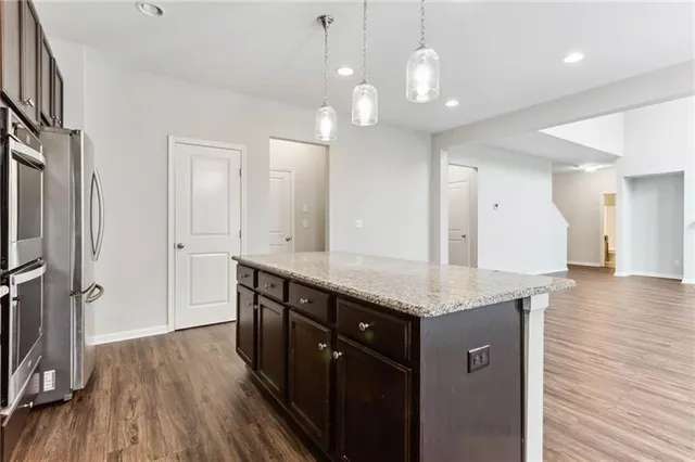 a bathroom with a granite countertop sink a toilet a large mirror and vanity