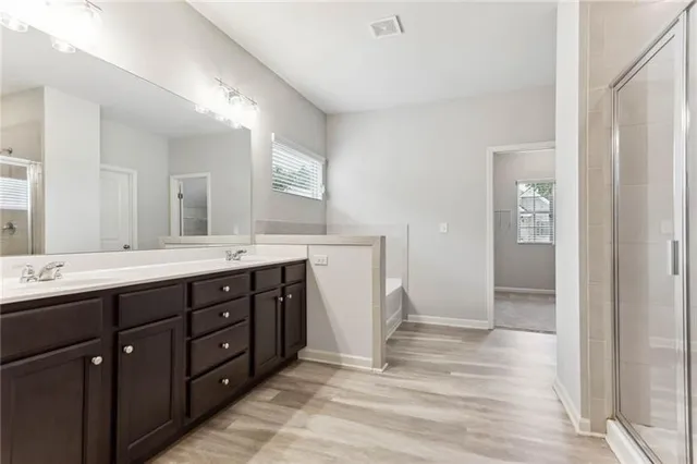 a spacious bathroom with a double vanity sink and mirror