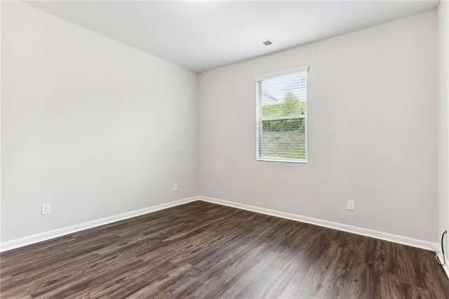 a view of a room that has wooden floor and window