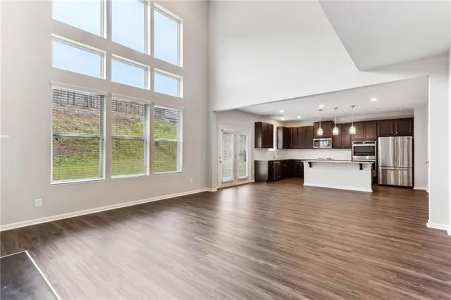 a view of a big room with wooden floor and windows