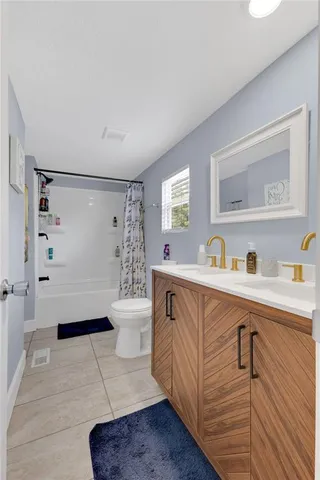 a spacious bathroom with a double vanity sink a mirror and a bathtub