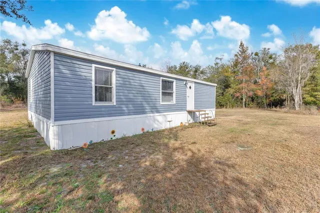 a backyard of a house with table and chairs