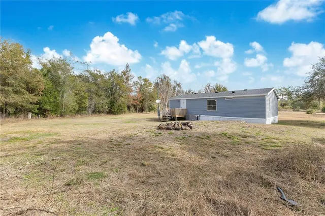 a view of a dry yard with wooden fence