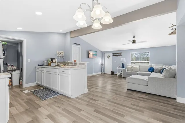 a living room with kitchen island furniture and a chandelier
