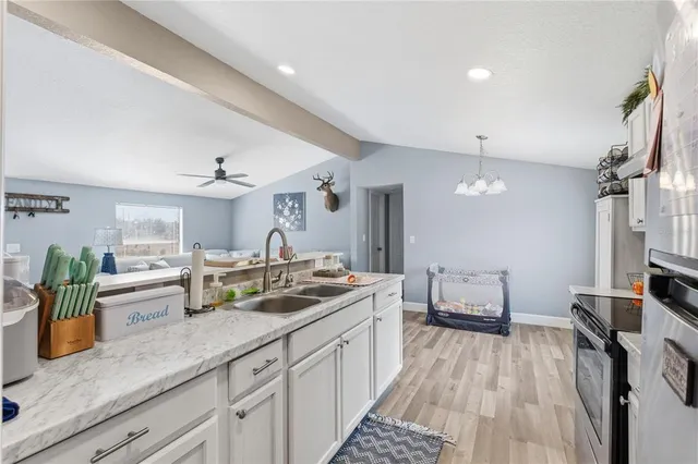 a open kitchen with a sink and wooden floor