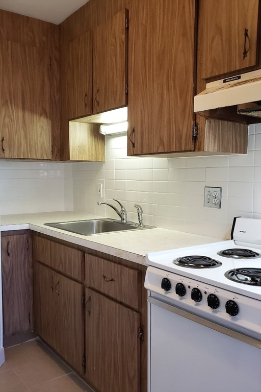 924 Beacon Street, Unit 6 Boston, MA 02215 - Photo 15 of 28 a white kitchen with sink a stove and a refrigerator