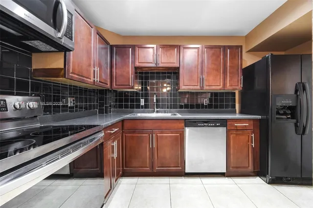 a kitchen with stainless steel appliances granite countertop wooden cabinets a sink and a stove