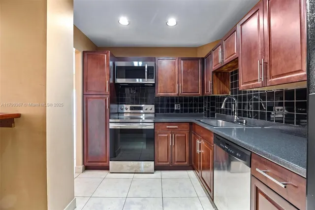 a kitchen with stainless steel appliances granite countertop a sink and a stove