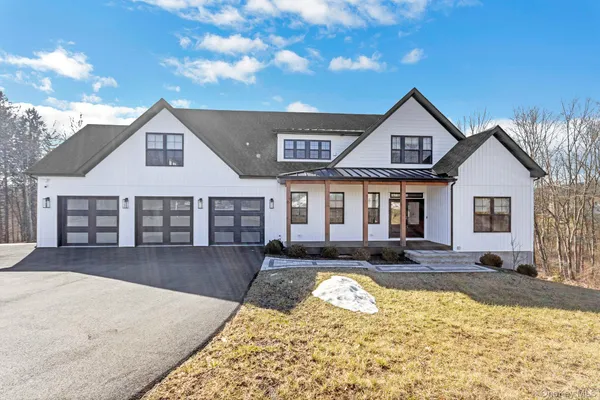 a front view of a house with a yard outdoor seating and garage