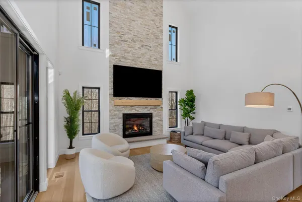 a living room with furniture a flat screen tv and a fireplace