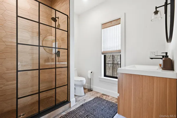 a bathroom with a granite countertop sink toilet and mirror
