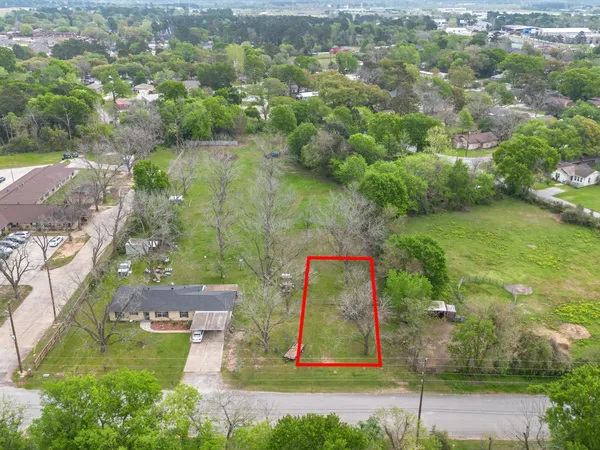 an aerial view of residential houses with outdoor space and trees