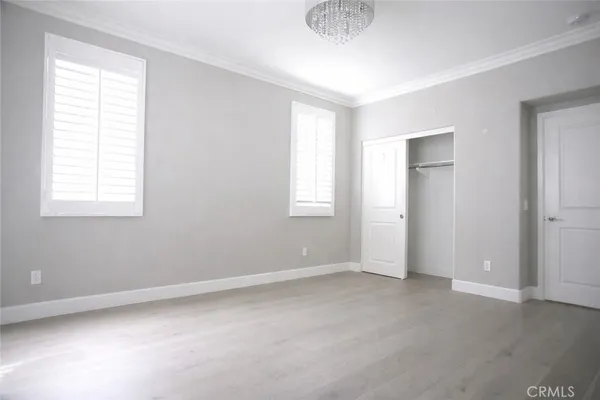 an empty room with wooden floor and glass door
