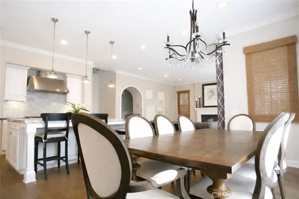 a dining room with furniture a chandelier and wooden floor