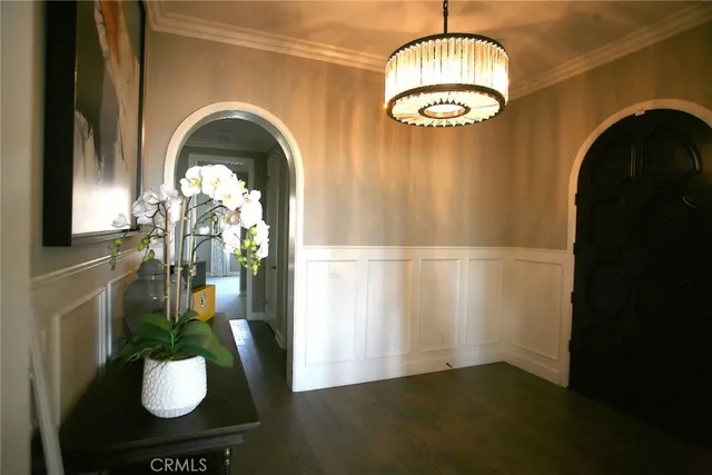 a kitchen with stainless steel appliances granite countertop a stove top oven a sink a dining table and chairs with wooden floor