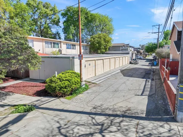 a view of a patio with plants and a bench
