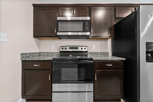 a kitchen with stainless steel appliances granite countertop a stove microwave and oven