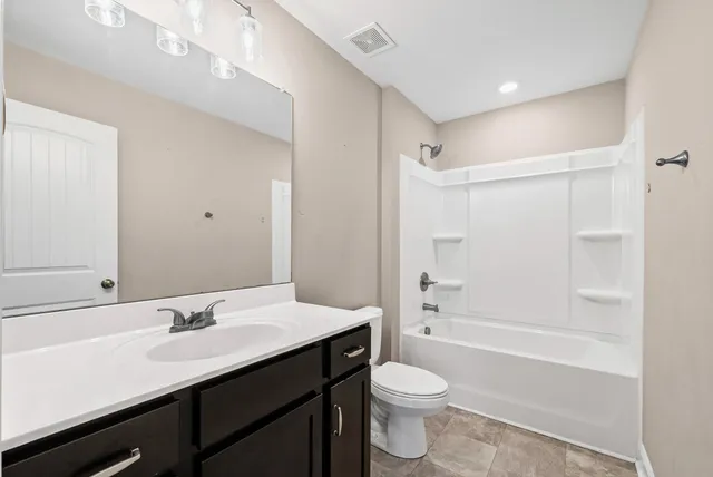 a bathroom with a granite countertop sink toilet a shower and a mirror