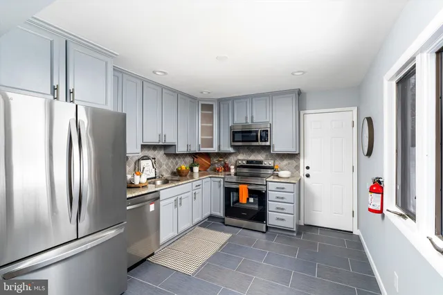 a kitchen with stainless steel appliances granite countertop a refrigerator stove a sink and dishwasher
