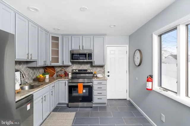 a kitchen with stainless steel appliances granite countertop a refrigerator and a stove top oven