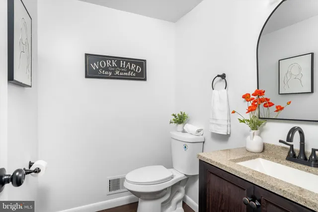 a bathroom with a granite countertop toilet sink and mirror