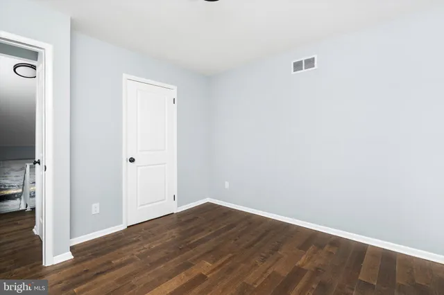 an empty room with wooden floor and a window