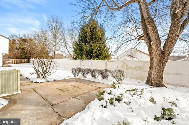 a view of a backyard with snow on the road