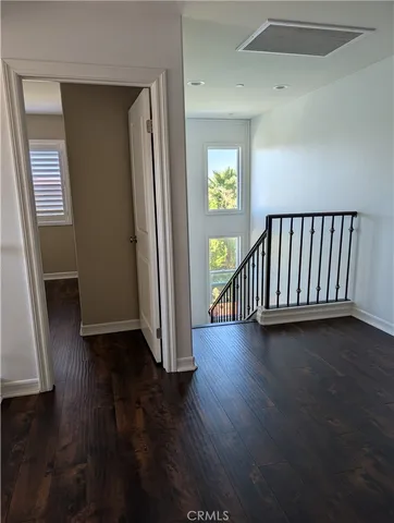 a view of a hallway with wooden floor and a window