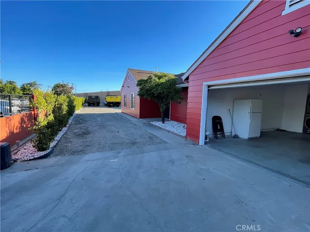 a view of a house with a yard and potted plants