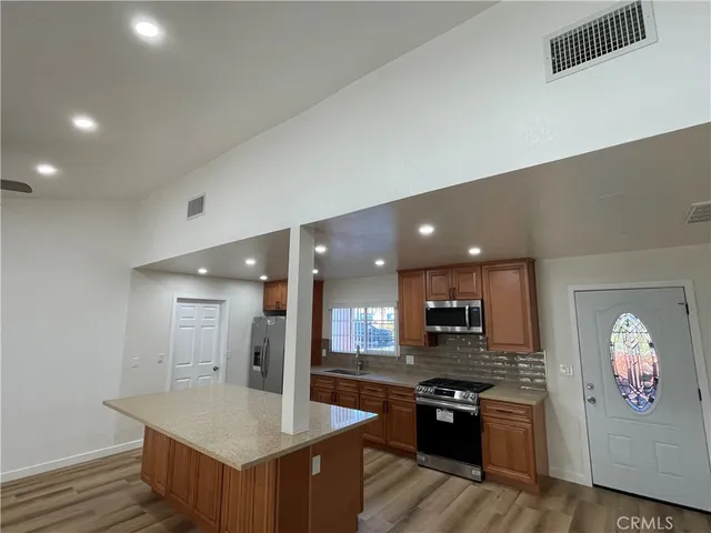 a large kitchen with stainless steel appliances granite countertop a large counter top and oven