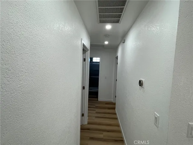 a view of a hallway with wooden floor and staircase