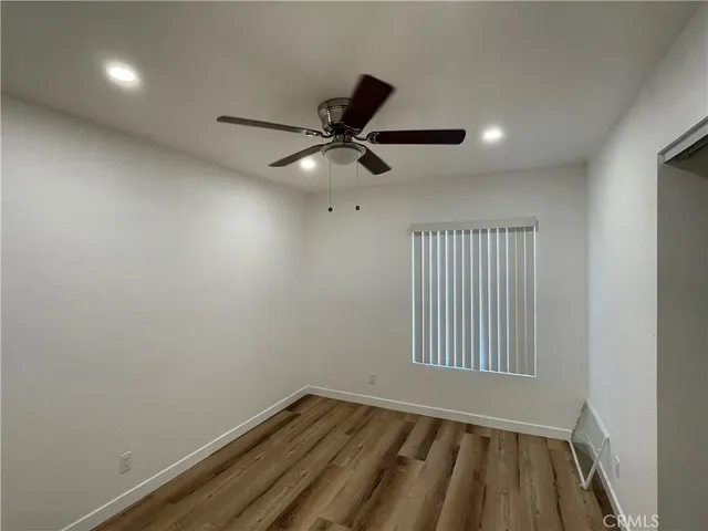 an empty room with a window and a ceiling fan