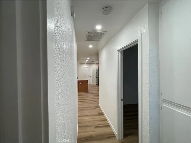 a view of a hallway with wooden floor and staircase