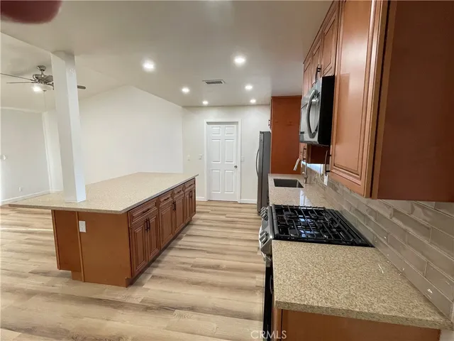 a kitchen with stainless steel appliances granite countertop a stove a refrigerator and a sink