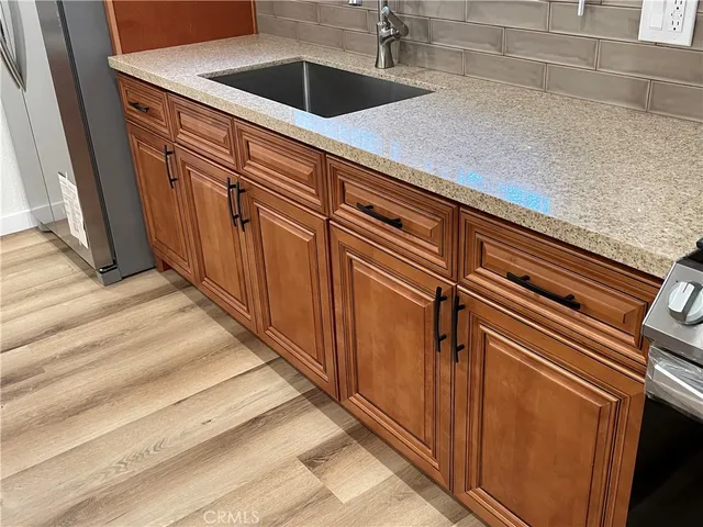 a view of a refrigerator in kitchen and an empty room