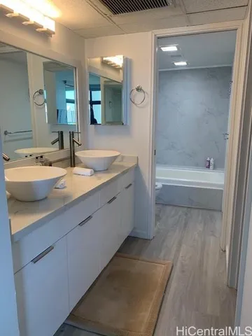 a bathroom with a granite countertop sink mirror and bathtub