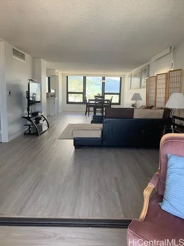 a living room with furniture and a wooden floor