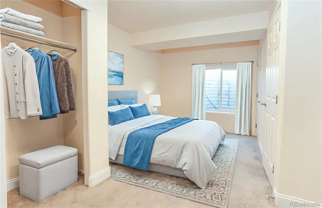 a bedroom with a bed a painting and a window