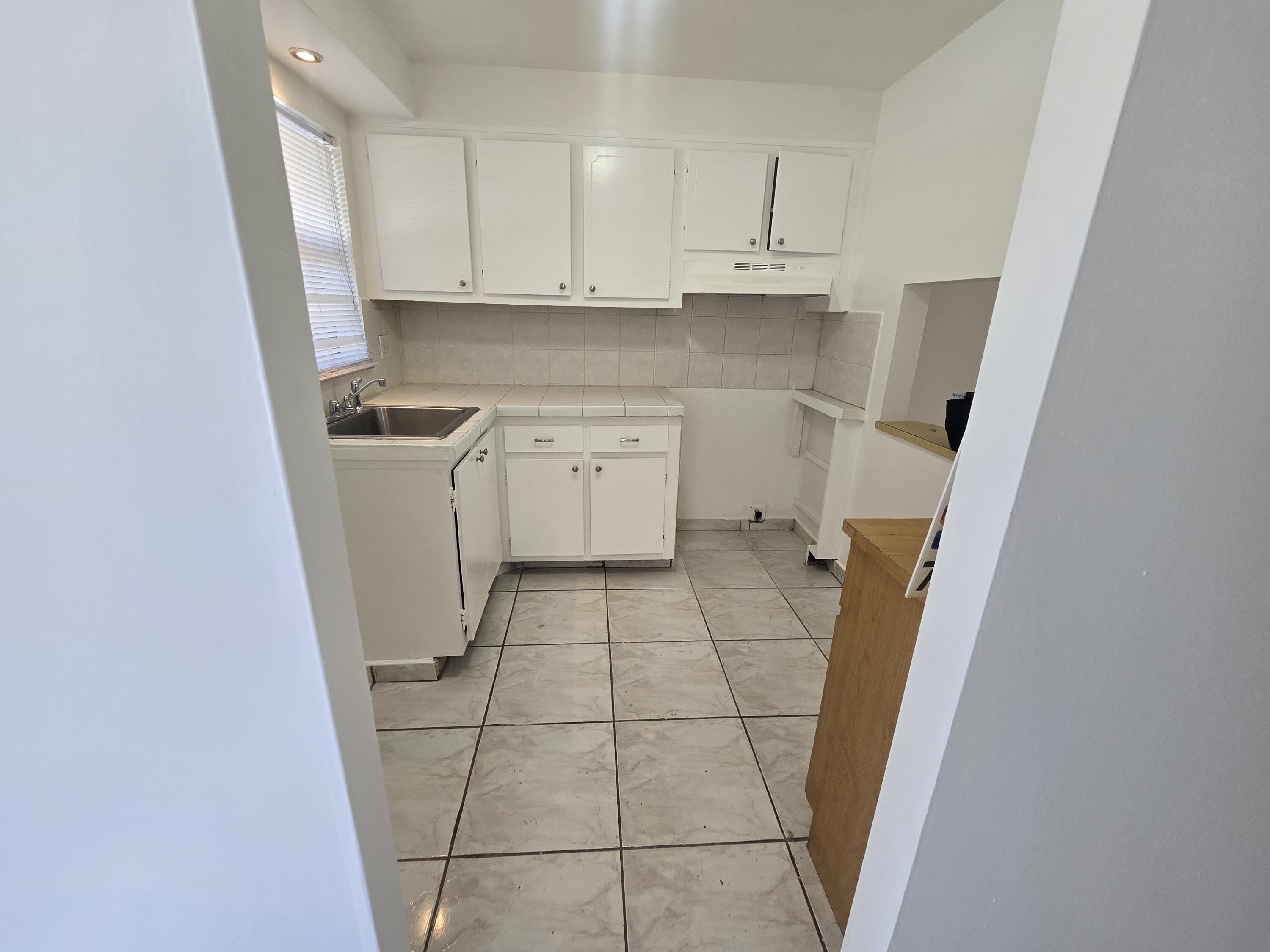 2741 North Pine Island Road, Unit 106 Sunrise, FL 33322 - Photo 7 of 14 a kitchen with a sink a stove and a refrigerator