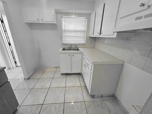 a kitchen with a sink a stove and cabinets