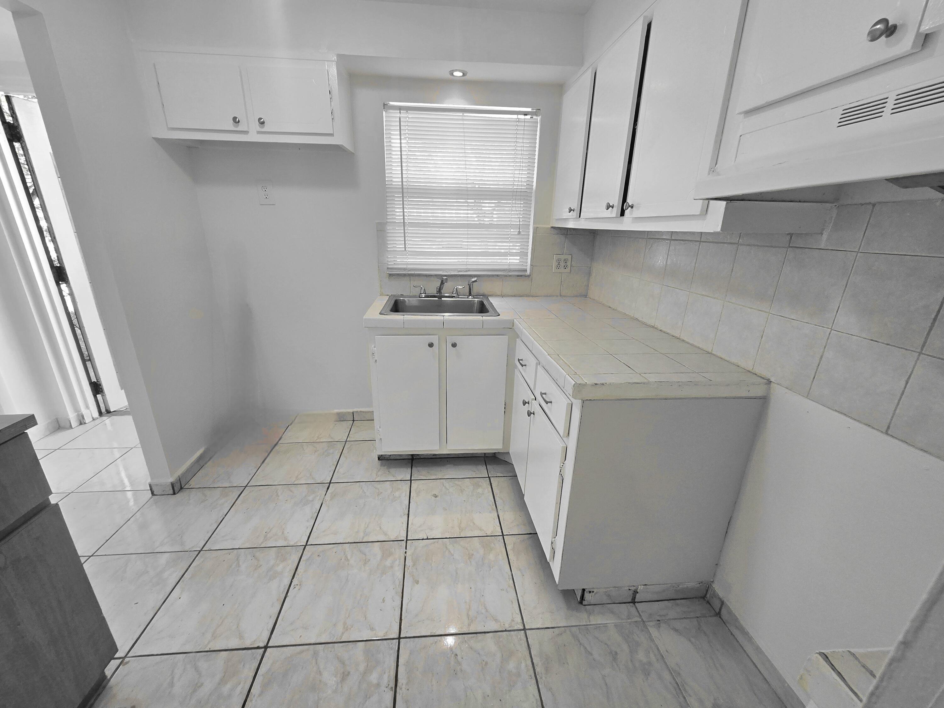 2741 North Pine Island Road, Unit 106 Sunrise, FL 33322 - Photo 8 of 14 a kitchen with a sink a stove and cabinets