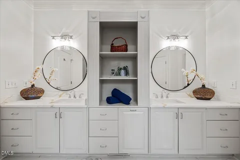 a hallway with white cabinets and wooden floor