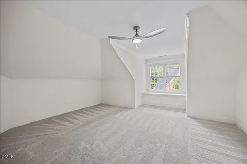 an empty room with a window and a ceiling fan